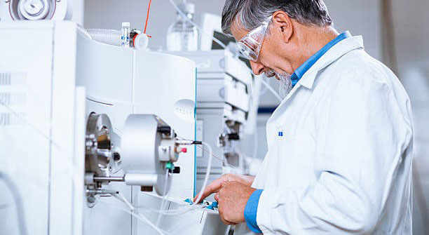 Man In Lab Examining Tubing